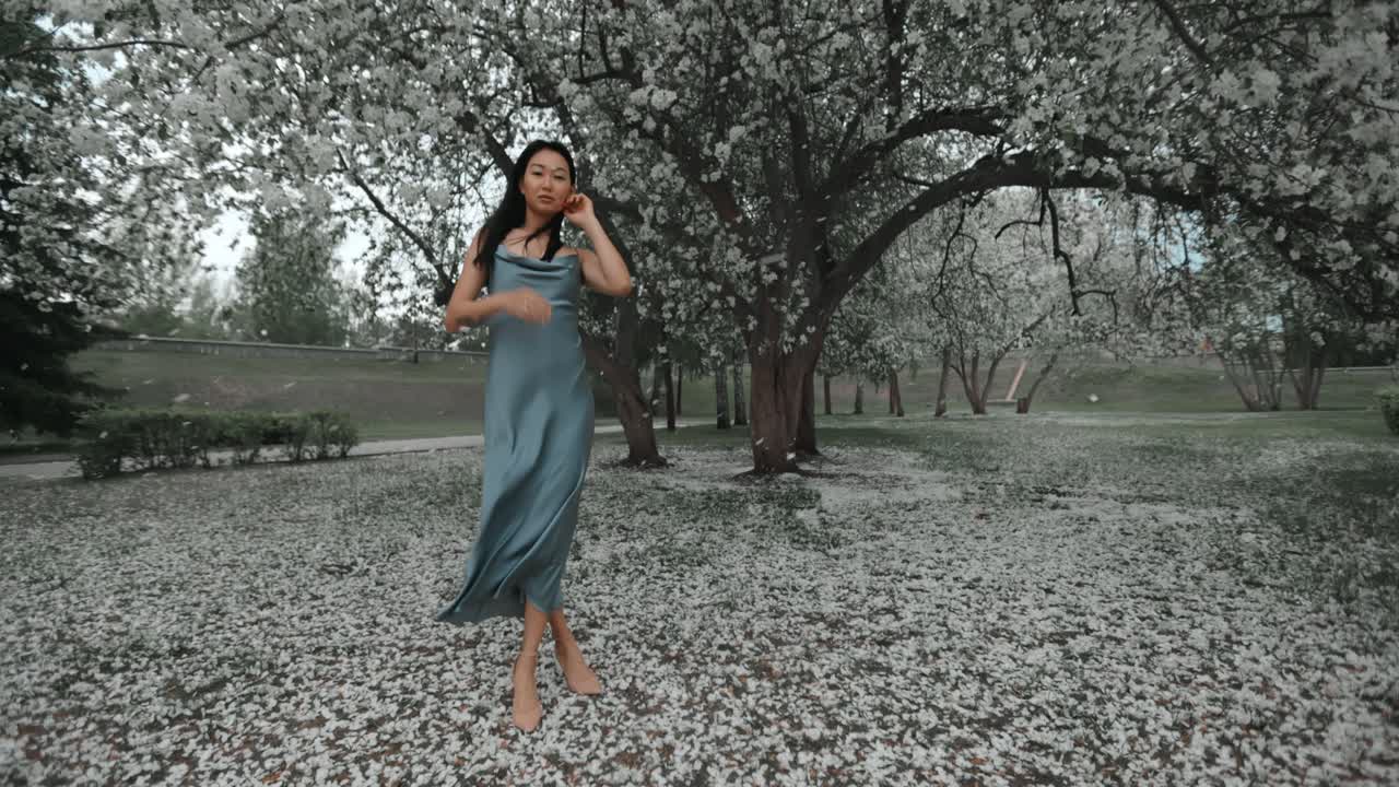 Woman in a Blue Satin Dress in a Spring Park
