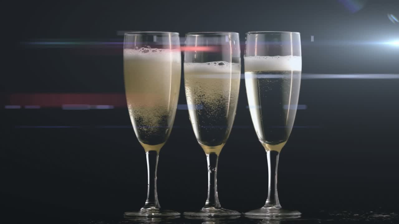 Three flutes with carbonation causing bubbles rising foam shifting glints forming for product ad