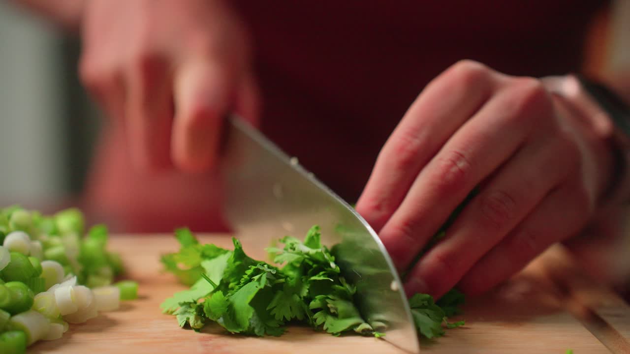 cortar cilantro a mano en la tabla de cortar