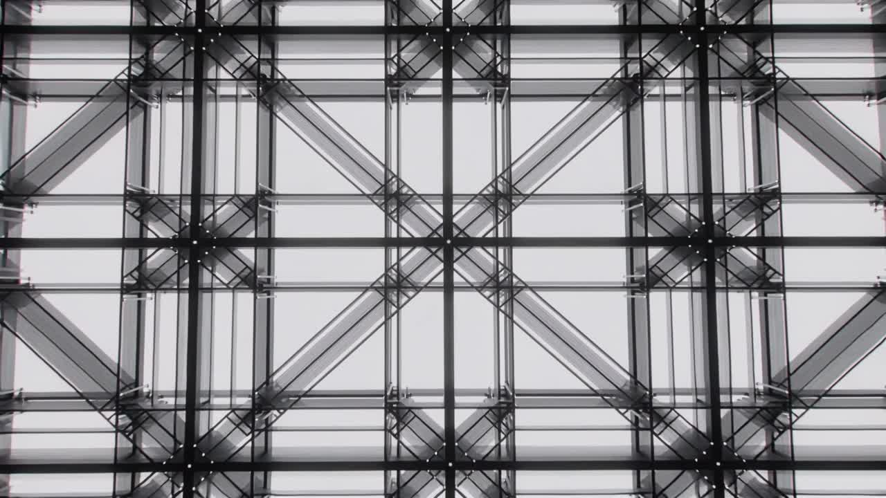 Vertical video: Pulling back camera revealing steel truss at atrium, exposing grid and bolts