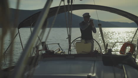 el capitán fumando en un yate al atardecer