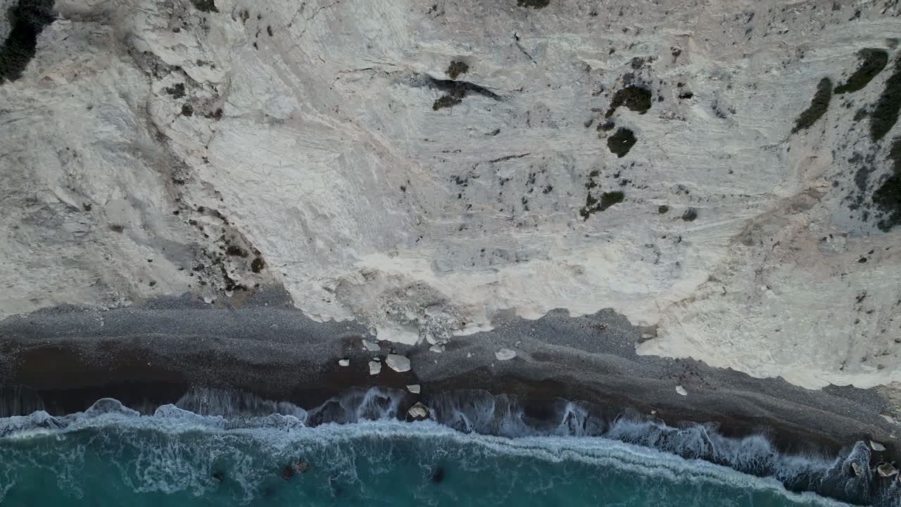 vista del acantilado de la costa cerca de la roca de afrodita, con las olas chocando contra los acantilados rocosos, creando un dramático paisaje marítimo bajo un cielo nublado