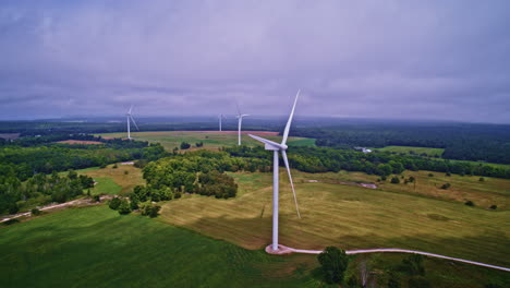 aerial drone shot sweeping across a rural area with wind turbines in northern michigan.