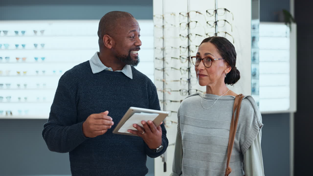 Optician helping customer choose eyeglasses