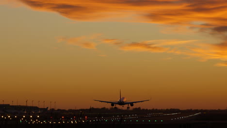 Silhouette-Eines-Flugzeugs,-Das-Während-Des-Filmischen-Sonnenuntergangs-Am-Flughafen-Landet