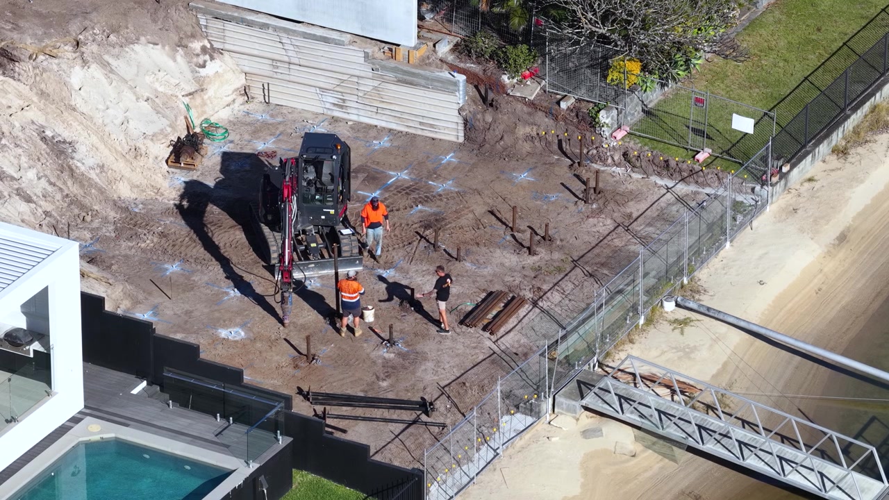Toma aérea de maquinaria y trabajadores preparando los cimientos de casas de lujo en Broadbeach Waters, Australia