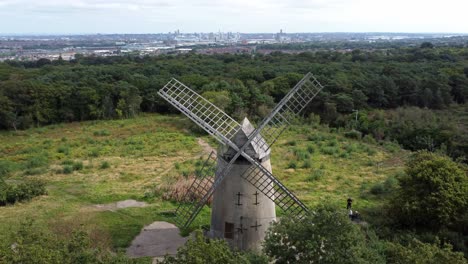 Bidston-hill-disused-rural-flour-mill-restored-traditional-wooden-sail-windmill-Birkenhead-aerial-view-left-orbit-above-trees