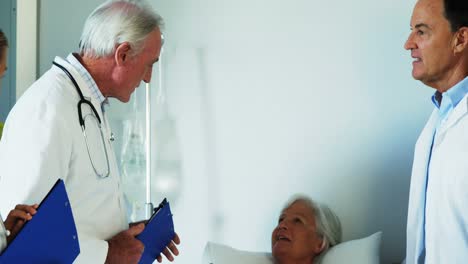 Group-of-doctors-discussing-report-with-old-woman