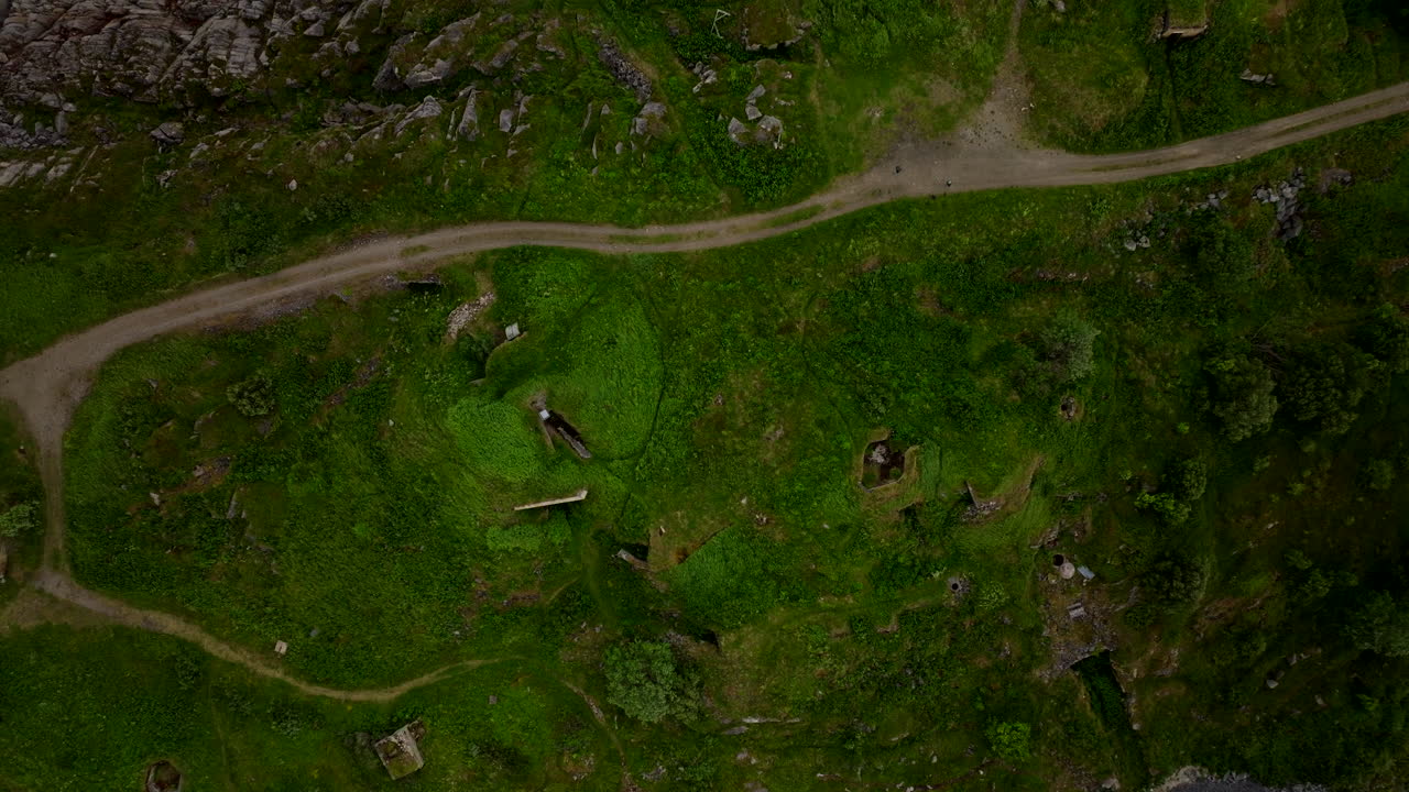 World War II ruins and bunkers at a coastal fort in Skrollsvik, Senja, Norway. Historic military defense site with abandoned fortifications seen from above