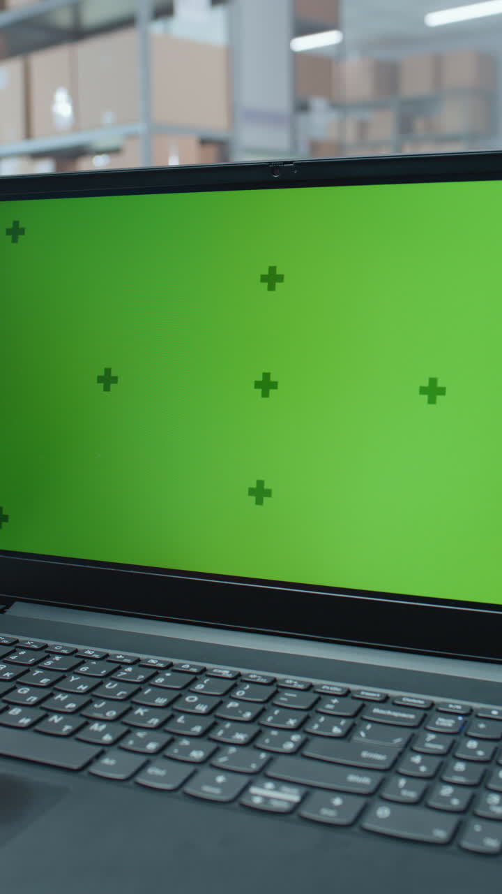 portátil con pantalla verde en un almacén