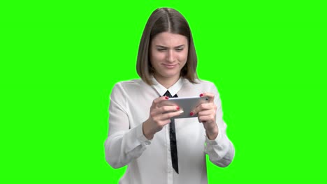una chica emocionada jugando videojuegos en su teléfono inteligente.