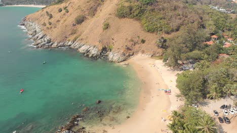 rocky shoreline and exotic landscape of yanui beach next to promthep cape - aerial low angle fly-over shot