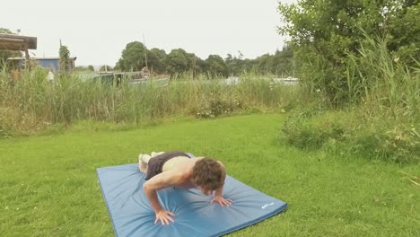 young athletic man doing pushups at outdoor home gym