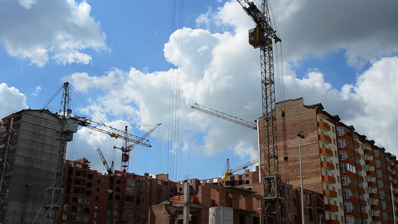 Grúas de construcción sobre casas. Construcción de edificios residenciales
