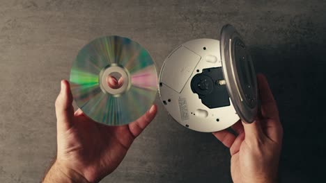 las manos abriendo un reproductor de cd vintage