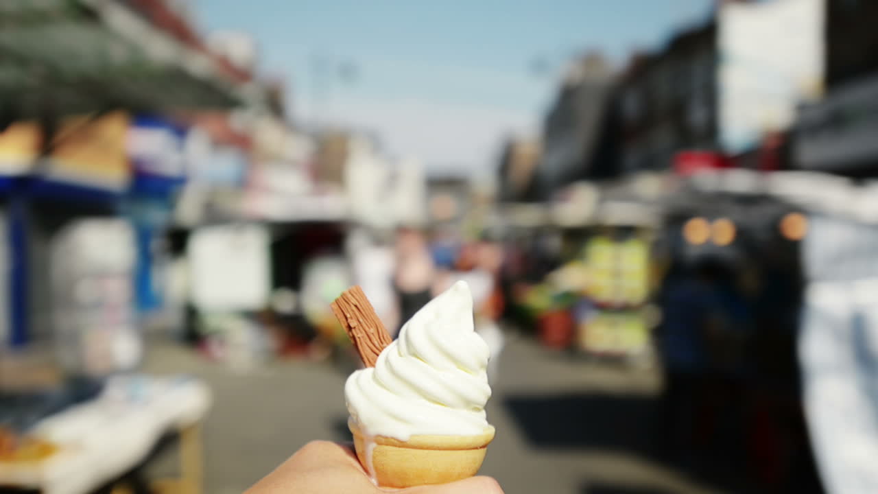 Punto di vista di un uomo con gelato che cammina al mercato