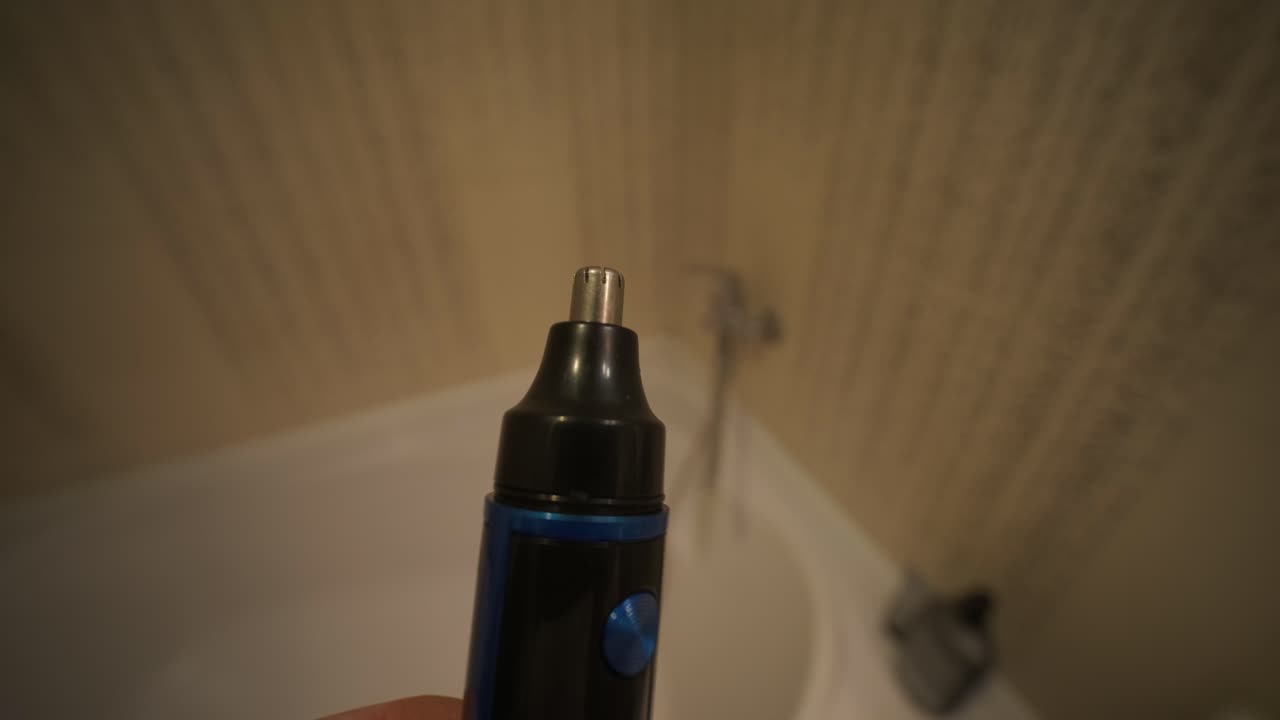 Electric Nose and Ear Hair Trimmer Operating in Bathroom
