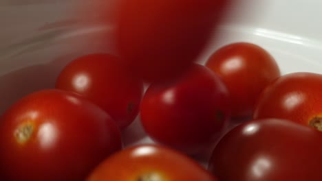 many small salad tomatoes fall into bowl until full