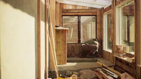 greenhouse interior renovation - man marking measurement on floor