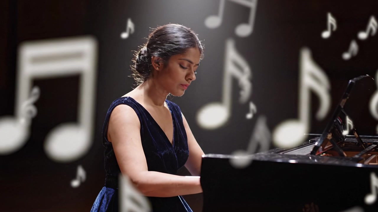En talentfuld pianist optræder smukt og fanger musikkens essens gennem hendes berøring af tangenterne, oplyst af et blødt spotlight i elegante omgivelser.