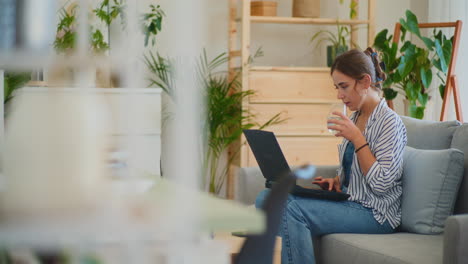 Businesswoman-Hydrating-While-Working-on-Laptop