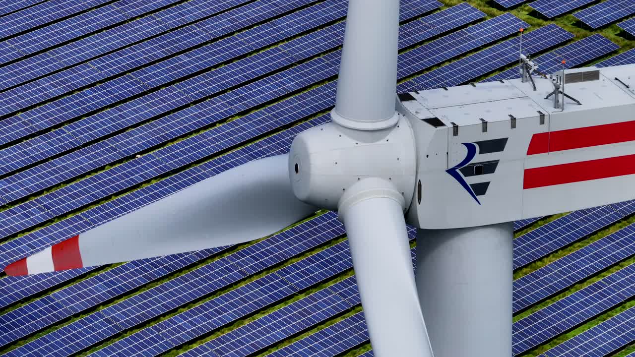 태양광 발전소 한가운데에서 깨 ⁇ 한 에너지를 생산하는 풍력 터빈의 클로즈업 - 텔레포토 렌즈 - 광 압축