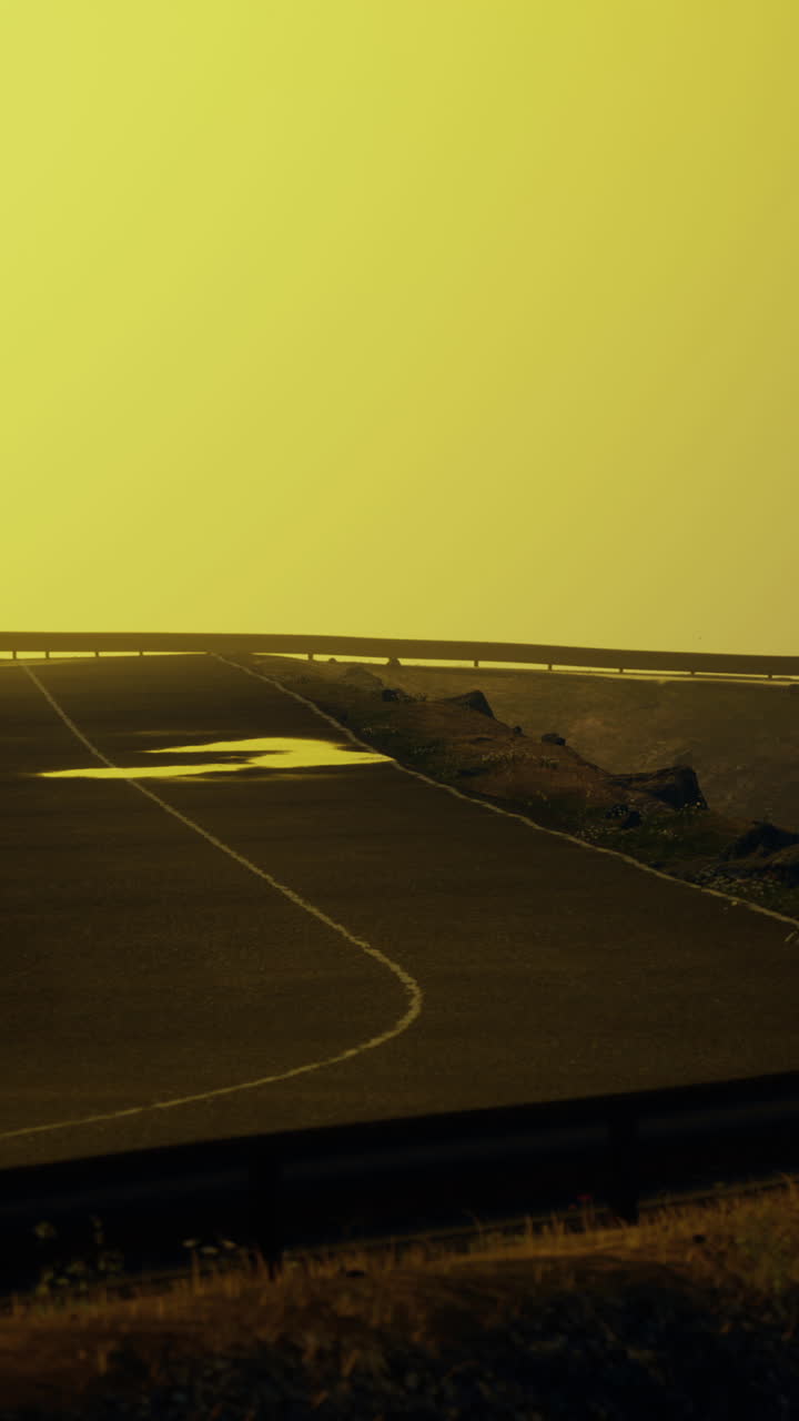autopista vacía que se extiende hasta el horizonte bajo un cielo amarillo
