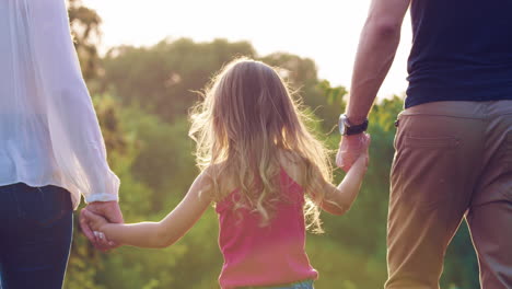 familia feliz tomándose de la mano en un soleado