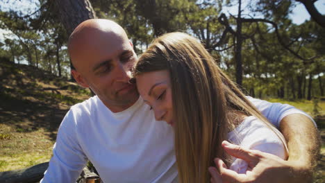 couple hugging and kissing in forest