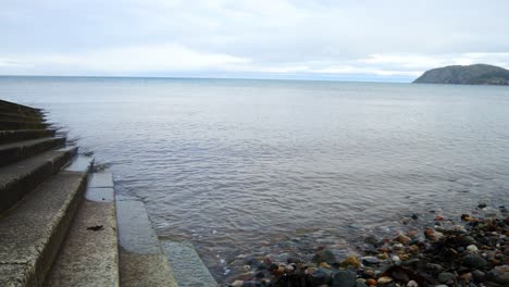 waves washing against concrete boat landing steps leading to ocean water dolly left