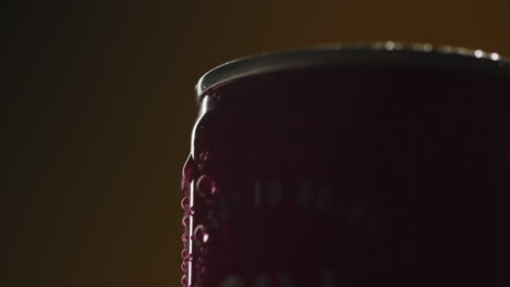 close up backlit shot of condensation droplets on revolving takeaway can of cold beer or soft drinks