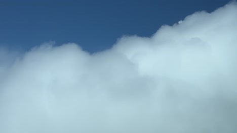 vista impresionante grabada desde una cabina de avión volando justo sobre la parte superior de una nube tormentosa