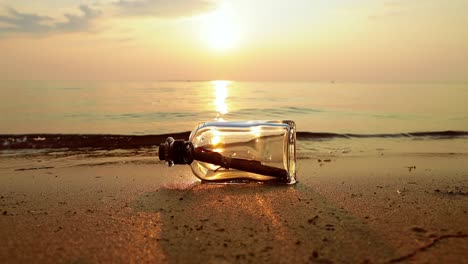 message in the bottle against the sun setting down