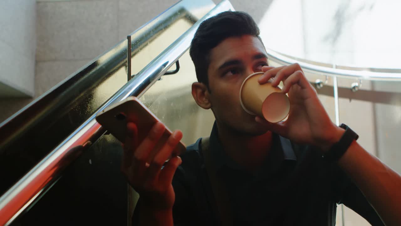 viajero masculino hablando por teléfono móvil mientras toma café 4k