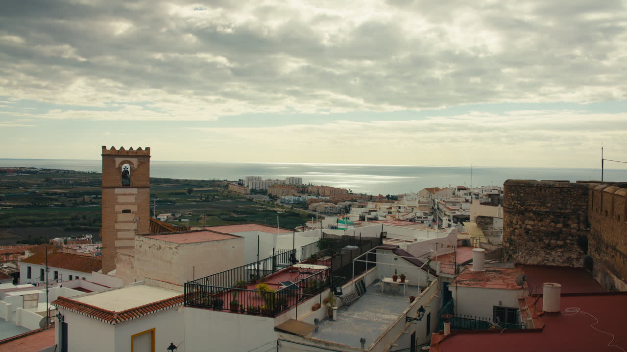 Vista elevata della storica Salobreña che mostra i vecchi tetti, il campanile della chiesa, i terreni agricoli costieri e gli edifici moderni vicino al Mar Mediterraneo