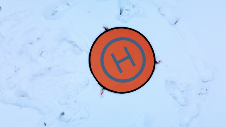 Drone Parking Apron Pad. Lies in the snow. Landing the drone with the camera down. Aerial photography.