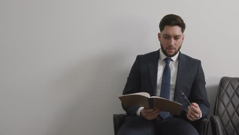 candidato masculino con traje en la oficina revisando notas antes de la entrevista de trabajo 1