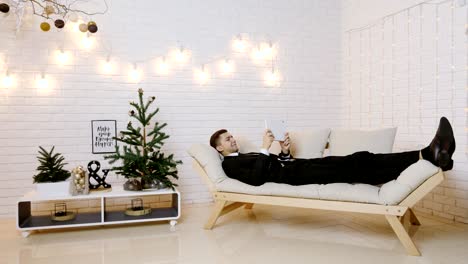 young man with tablet computer on sofa