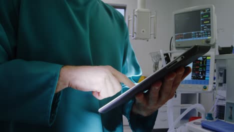 cirujano usando una tableta digital en la sala de operaciones