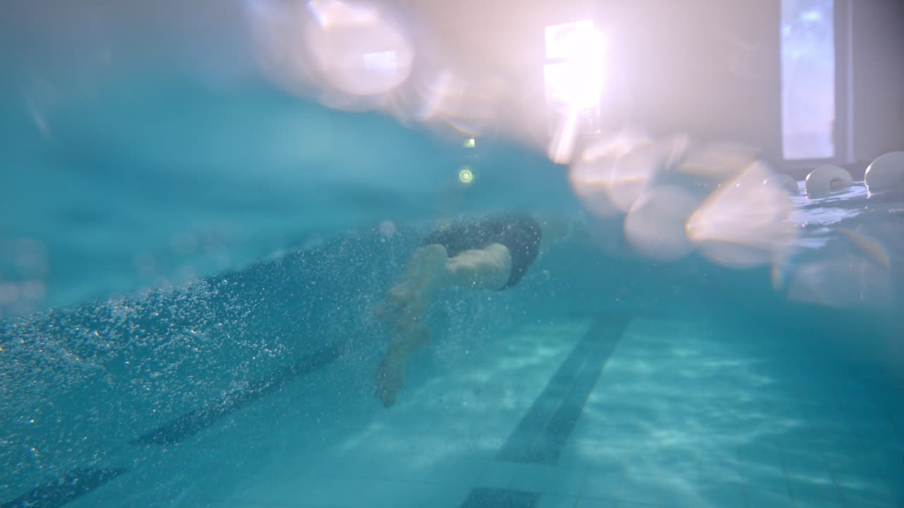A person swimming in an indoor pool