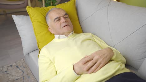 Thoughtful-old-man-lying-on-sofa-at-home-confused.