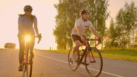 Two-cyclists-ride-together-in-mountains.-Softly-focused-hand-held-shot-of-two-professional-cyclists-from-sport-team-having-fun-during-hard-training-sprinting