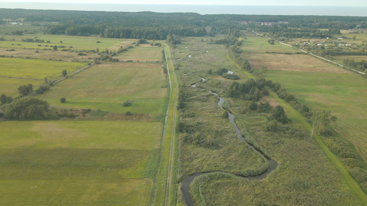 el hermoso paisaje del amplio campo verde en debki, polonia durante el día soleado - toma aérea