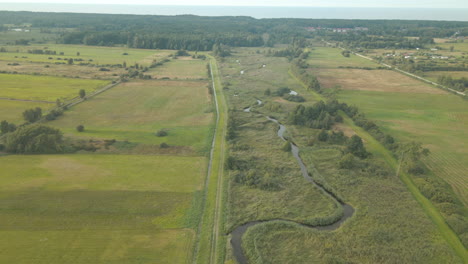 Die-Wunderschöne-Landschaft-Der-Weiten-Grünen-Wiese-In-Debki,-Polen-An-Einem-Sonnigen-Tag---Luftaufnahme