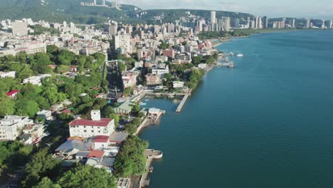 Skyline-at-Tamsui-district-in-Taipei-by-the-river,-Aerial-Reveal-Ascending-Shot