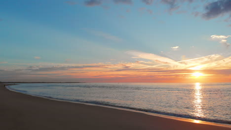 Eine-Ruhige-Ebbe-Am-Strand-In-Der-Nähe-Des-Sturmflutwehrs-Im-Südwesten-Der-Niederlande,-Während-Des-Sonnenuntergangs