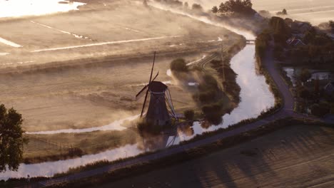 misty dutch sunrise with windmill