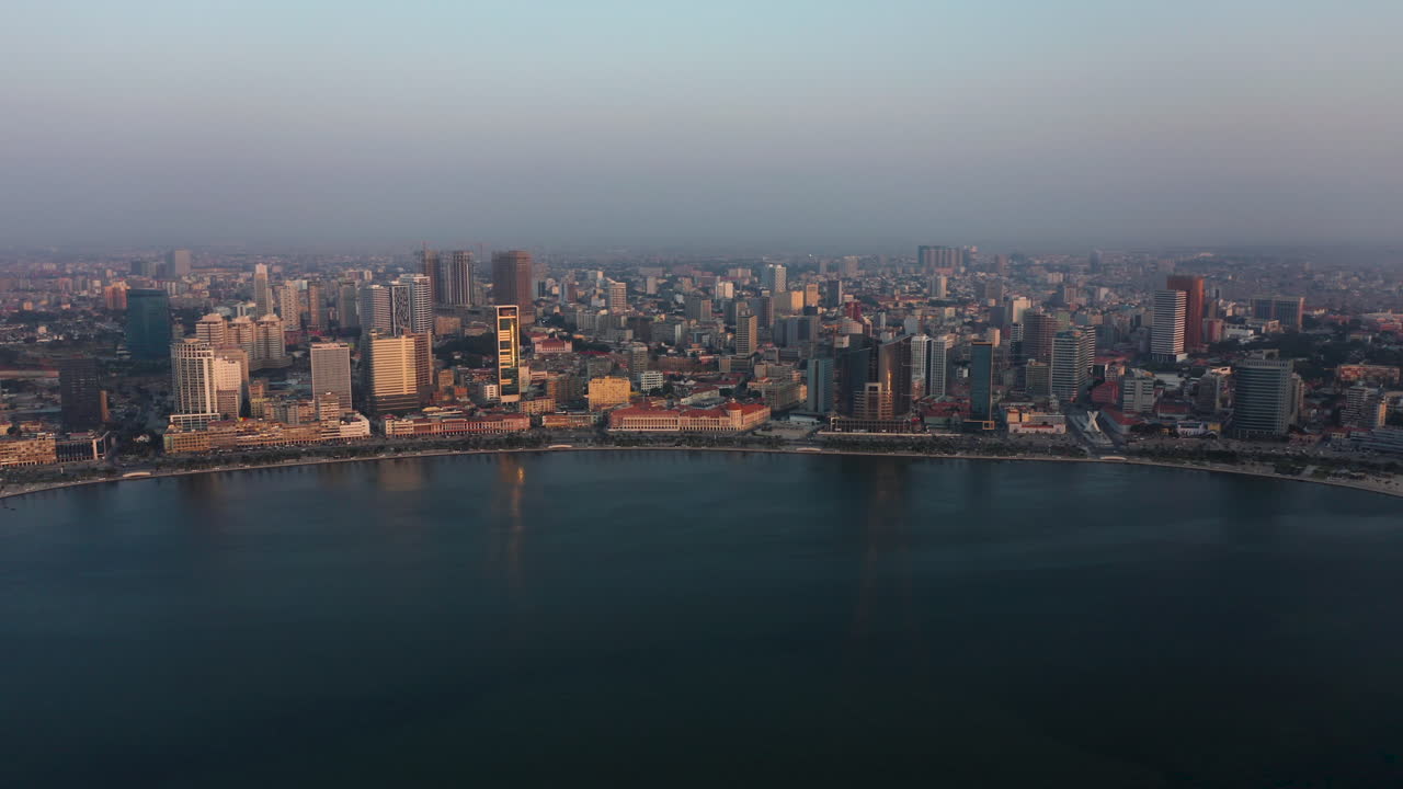 Traveling front, sky line Luanda city, golden hour flying over Luanda bay, Africa
