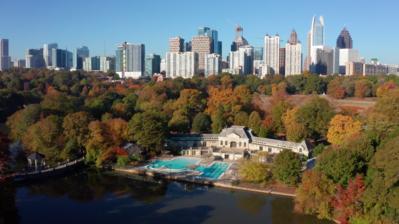 Flying over Piedmont Park above the public pool looking at downtown Atlanta Georgia