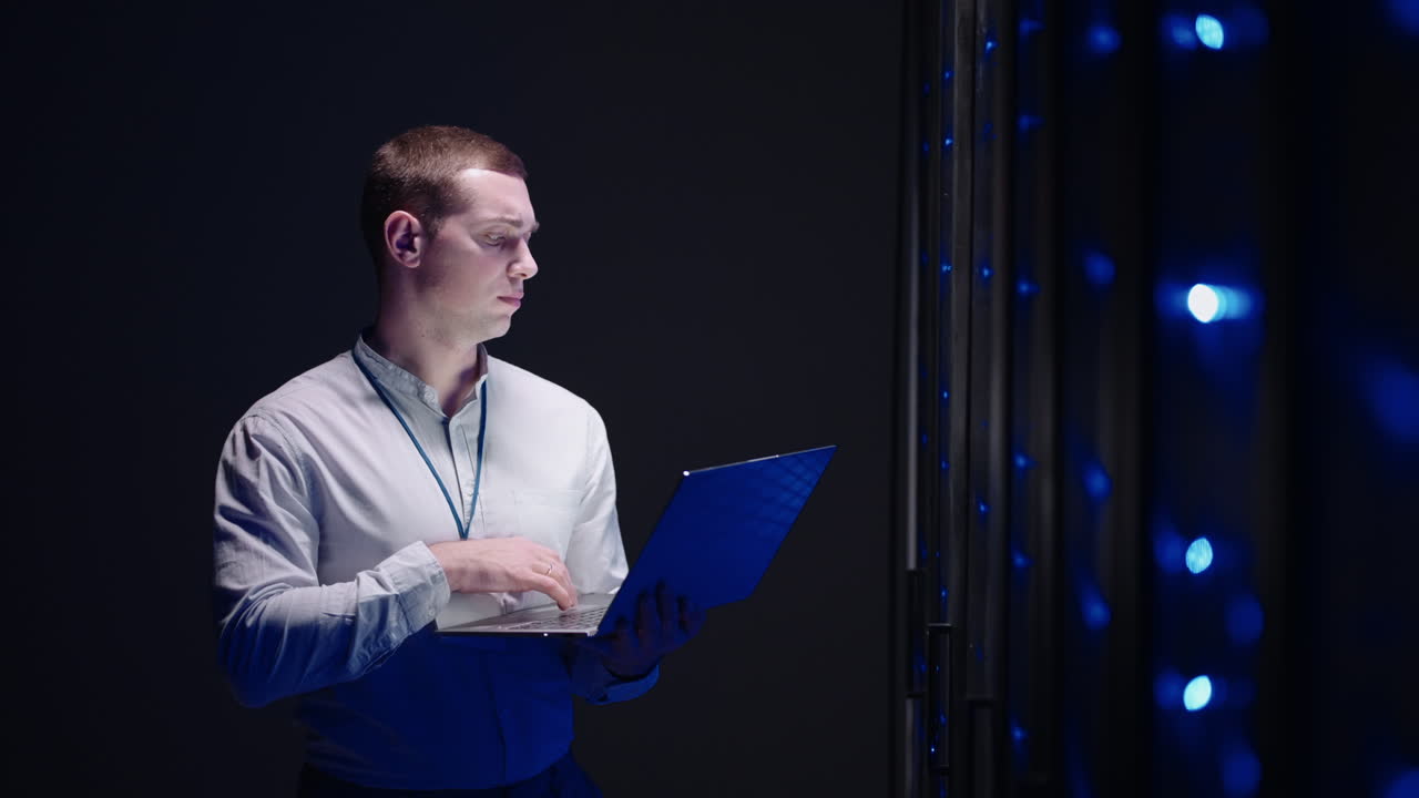 un técnico hombre con una computadora portátil en la sala del servidor